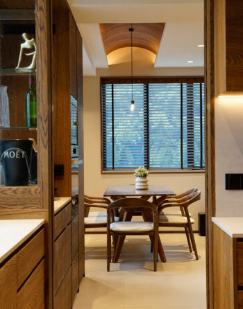 Warm wooden dining area with natural light and pendant lamp.
